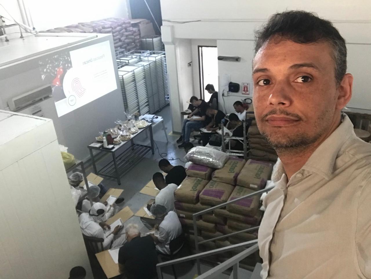 André Lázaro em primeiro plano, com participantes de um treinamento na fábrica da Bon Mess